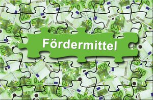 Puzzel-Teile mit 100-Euro-Geldscheinen und dem Aufdruck Fördermittel