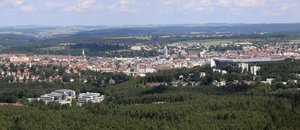 Bild mit einem Stadtpanorama von oben fotografiert. Stadt umgeben von vielen Wäldern