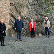 7 Personen stehen vor altem Gemäuer auf Felsen