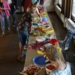 Tische mit vielen Speisen, Kinder und Erwachsene wählen Speisen aus