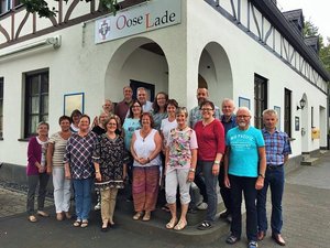 Gruppenbild mit Männers und Frauen vor einem Dorfladen