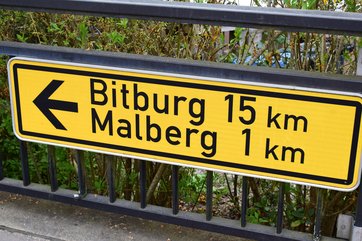 Landstraßenschild mit Richtungspfeil Bitburg 15 km