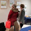 Zwei Frauen betrachten Bilder einer Cartoon-Ausstellung