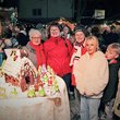 Blick über das erleuchtete Weihnachtsdorf mit Besucher*innen jeden Alters